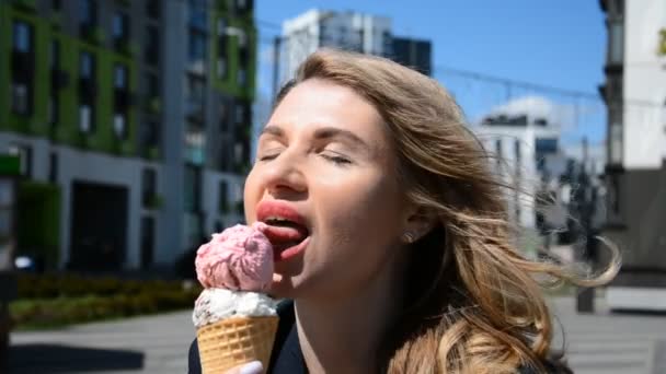 Porträt einer blonden Frau auf der Straße, die Eis isst — Stockvideo
