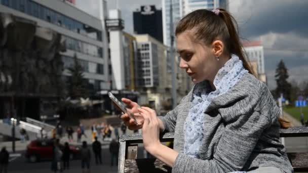 Alegre estudiante caucásica usando teléfono inteligente — Vídeo de stock