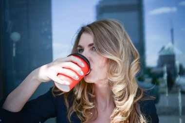 İş merkezinde kahve içen bir iş kadını.