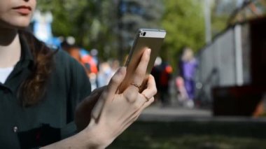 Kadın Eller, görüntüyü kapatın. Şehir parkındaki Kırmızı Akıllı Telefon uygulamasını kullanın.