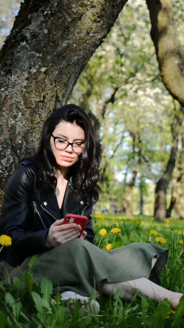 Jeune fille élégante caucasienne est assis dans un parc un jour d'été — Video