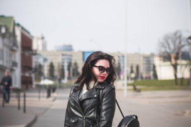 Güneşli bir günde, ilkbaharda güzel bir hippi kız şehrinin caddesinde yürür.