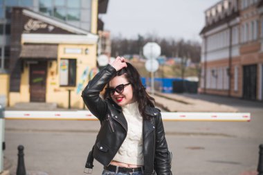 Güzel genç kız hippi kız ilkbaharda şehrinin caddesinde yürüyor.