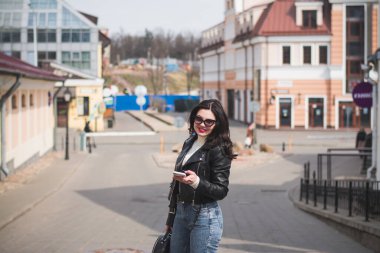 Güzel genç kız hippi kız ilkbaharda şehrinin caddesinde yürüyor.