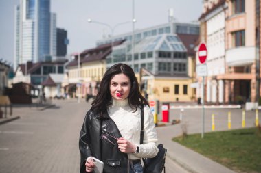 Güzel genç kız hippi kız ilkbaharda şehrinin caddesinde yürüyor.