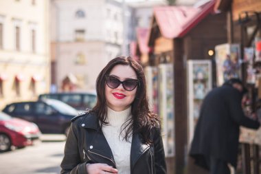 Güneşli bir günde, ilkbaharda güzel bir hippi kız şehrinin caddesinde yürür.