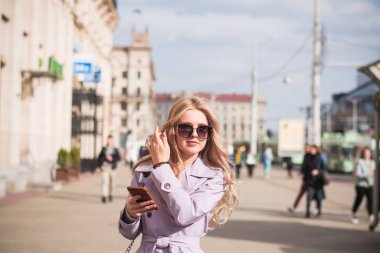 Yaşam tarzı konsepti. Şehirde güzel bir kız sokakta yürüyor.