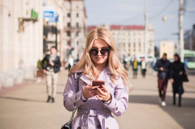 Yaşam tarzı konsepti. Şehirde güzel bir kız sokakta yürüyor.