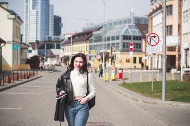 Şehrinin sokaklarında yürüyen güzel, genç, esmer bir hippi kız yürüyor ve seviniyor.