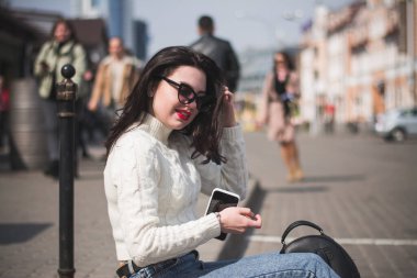 Şehrinin sokaklarında yürüyen güzel, genç, esmer bir hippi kız yürüyor ve seviniyor.