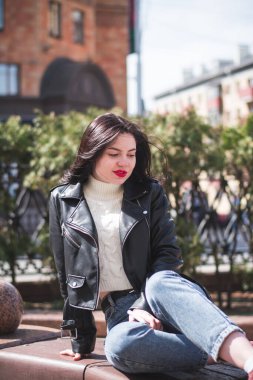 Şehrinin sokaklarında yürüyen güzel, genç, esmer bir hippi kız yürüyor ve seviniyor.