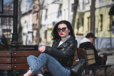 Şehrinin sokaklarında yürüyen güzel, genç, esmer bir hippi kız yürüyor ve seviniyor.