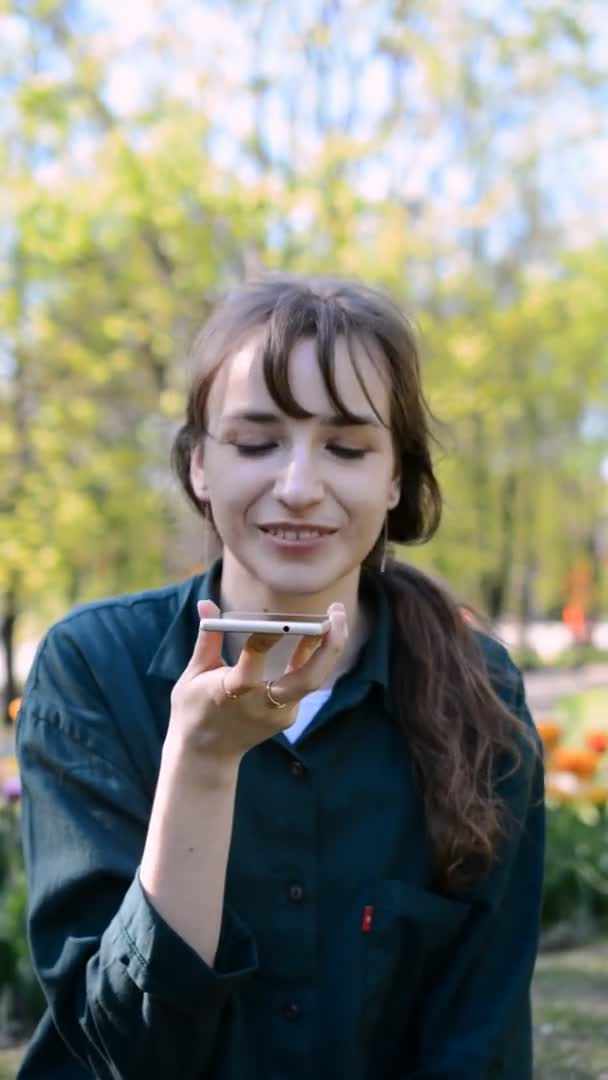 Hermosa chica joven feliz sonriendo y hablando en un teléfono móvil — Vídeo de stock