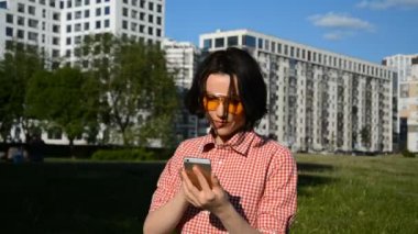 Mutlu genç kız telefonda bir mesaj yazıyor.