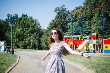 Güzel bir Rus kızı yazın şehir parkına gelir ve sevinir.