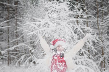 Karlı bir ormanda Noel kıyafetleriyle güzel bir kız.