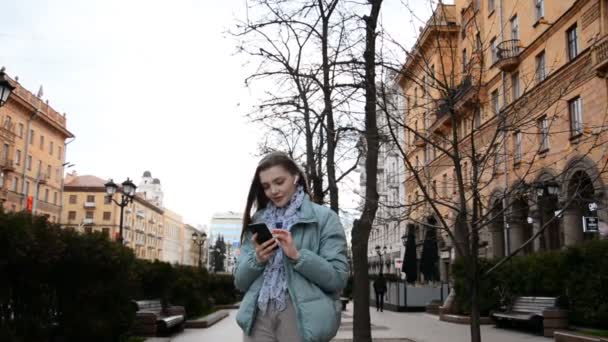 Девушка радуется и читает сообщение по телефону — стоковое видео