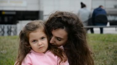 Küçük tatlı kızının annesine sarılıp burnuna dokunduğu bir sahne.