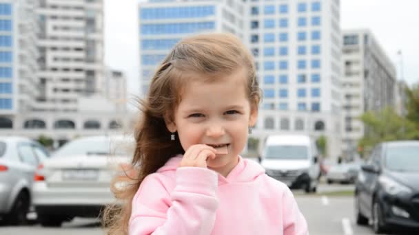 초콜릿 바를 먹고 있는 작고 아름다운 소녀 사진 — 비디오