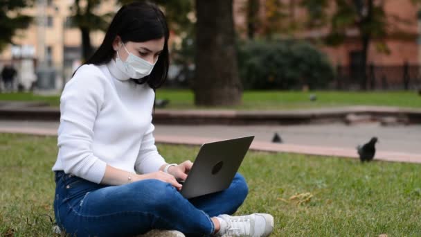 백인 여성 보호 마스크를 쓰고 노트북 컴퓨터로 일한다 — 비디오