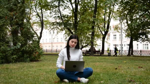 Fókuszált kaukázusi nő használja notebook dolgozni online zöld fű — Stock videók