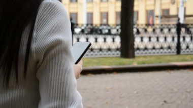 Şehirdeki bir kız akıllı telefondan mesaj yazıyor.