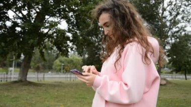 Güzel kız akıllı telefonuna bir mesaj yazar.