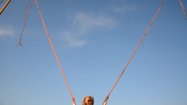 Little happy girl having fun in the park and jumping on the tramline — Stock Video