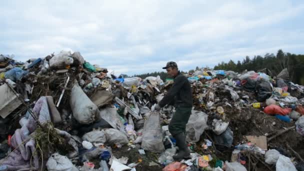 MINSK, BELARUS - 2021年9月27日:貧困の概念、成功、ビジネス、ゴミ捨て場と男は食べ物に廃棄物を収集します — ストック動画