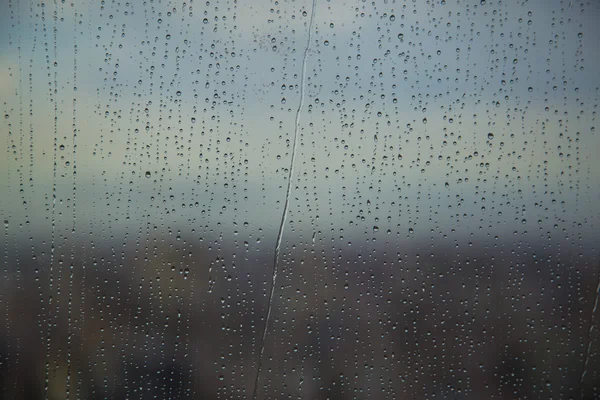 Sztuka wzór kropli wody na wieży okno po deszczu, na tle. — Zdjęcie stockowe