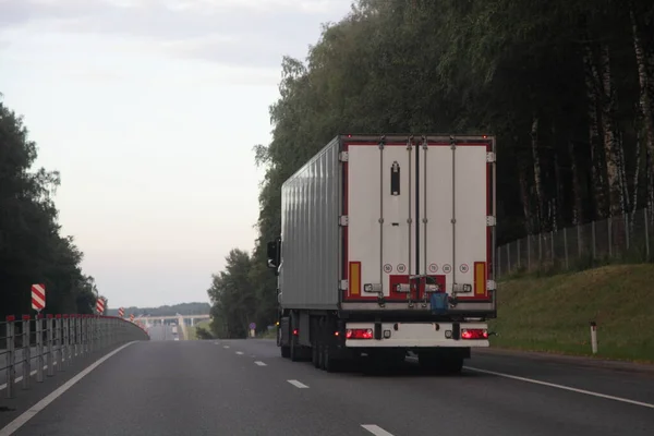 유럽의 차량과 흰색의 트레일러 차선을 아스팔트가 고속도로로 운행하며 경로등을 수있다 — 스톡 사진