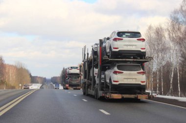 İki katlı SUV taşıma kamyonları ve yarı karavanlar kış günü banliyö otobanında, arka taraf manzarası kapalı, teslimat otomobili lojistik, otomobil taşımacılığı