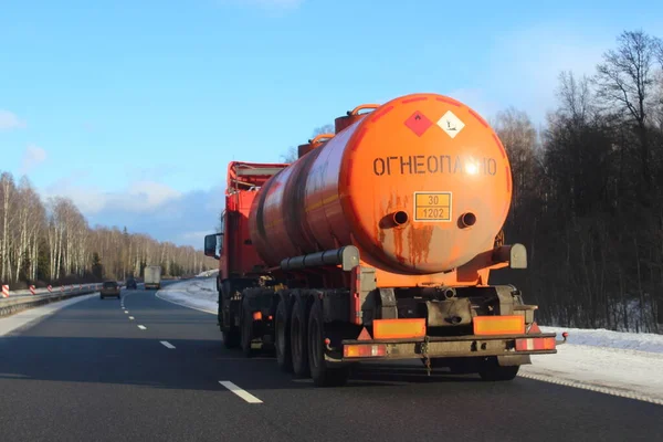 装有301202个Diesel危险等级标志和俄文本Flammable的橙色枪管半燃料卡车在冬季前夕行驶在近郊公路上 从侧面看Adr危险货物 — 图库照片