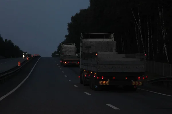 Düşük Yataklı Karavan Kamyonları Karanlıkta Asfaltlanmış Gece Yoluna Çıkarlar Ulaşım — Stok fotoğraf