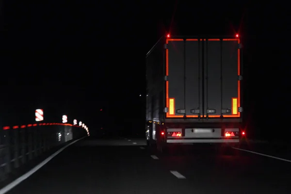 半挂车 背板上有照明反射条纹 在黑暗中的干湿柏油夜路上行驶 后视镜 新建运输物流 — 图库照片
