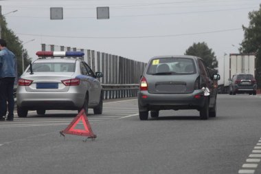 Rusya 'da trafik kazası, trafik kazası Wiyh' in arka plandaki trafik lambası ve Rus polis arabasının bozulması yaz akşamı banliyö otobanında kırmızı üçgen işareti.