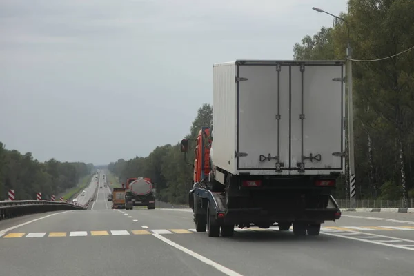 汽车承运人卡车在郊区高速公路上运送货车 后视镜 汽车物流 汽车运输 — 图库照片