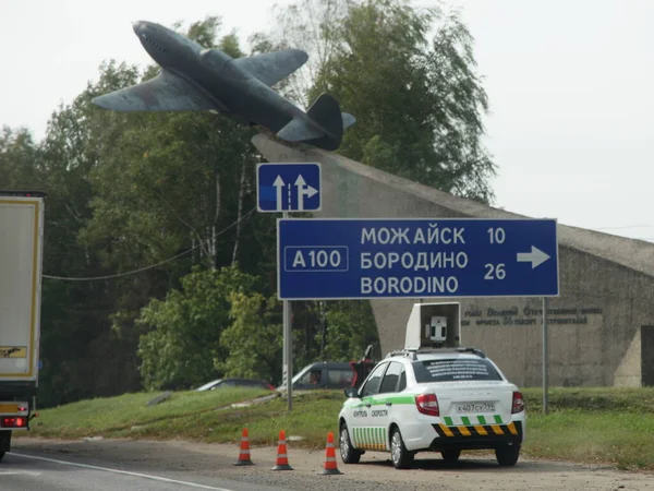 Moscow Region, Russia 09 04 2020: Speed control car with speedgun on roof on roadside on Borodino crossroads near monument to the airplane in Moscow area at summer day — Stock Image Moscow Region Russia 2020 Speed Control Car Speedgun Roof Roadside Royalty Free Stock Images