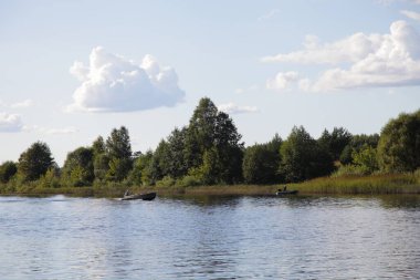 Yeşil ormanı olan güzel Volga nehri kıyısı. Mavi gökyüzünde durgun su. Yaz gününde beyaz bulutlar.