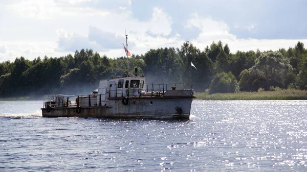 在阳光明媚的夏日 一艘苏联小型拖船在平静的河水上缓缓漂浮 在森林和多云的天空背景下 进行户外娱乐活动 — 图库照片