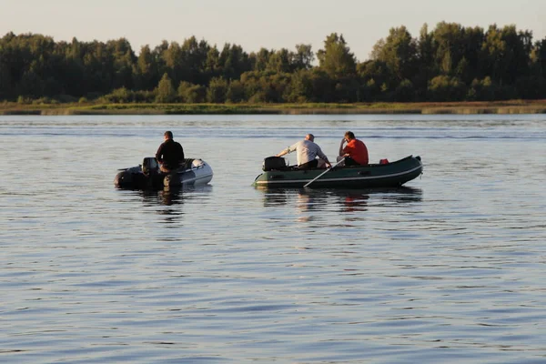 Fisherman people on two PVC inflatable motor boats on river against the background of the far Bank with a green forest on the horizon on a summer morning, fishing on the river — Stock Image Fisherman People Two Pvc Inflatable Motor Boats River Background Far Stock Image