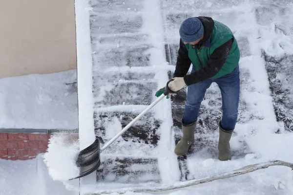 Pracownik Bez Pasów Bezpieczeństwa Kasku Czyści Śnieg Dachu Łopatą Zimowy — Zdjęcie stockowe