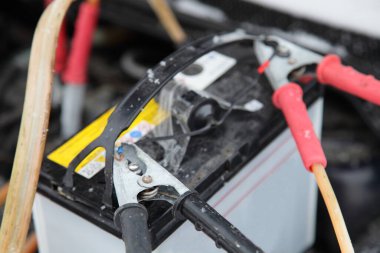 Araba aküsü biriktirici. Timsah derisi klipsli kablolar, donmuş araba dizel motoru. Soğuk kış gününde soğuk hava aküsüyle çalışmaya başla.