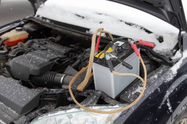 Araba benzini motoru, soğuk kış gününde yedek pil akümülatörü ve timsah derisi klipsli kablolarla soğuk bir başlangıç yapar.