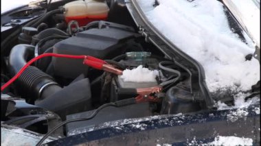 Başlangıç kablolarını birbirine bağlayın. Timsah konnektörleri donmuş araba aküsüne krampon takar ve soğuk bir kış gününde her gece hızlı bir soğuk başlama motoru park eder. Kaputu açık kaputla kapatın.