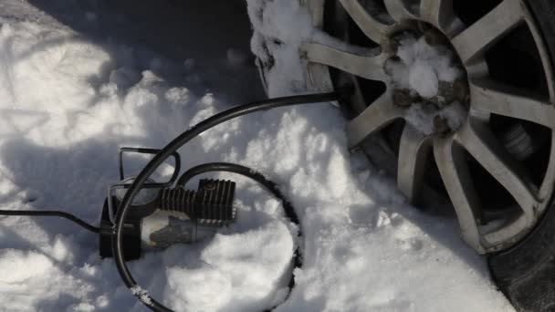 Portable Electrical Air Tire Compressor Inflates Car Wheel White Snowdrift — Stock Video