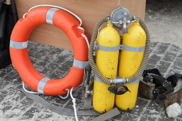 Scuba diving tanks, orange lifebuoy ring and ballast weights, lifeguard equipment set for professional diving rescue