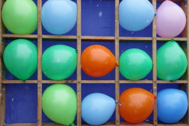 Birçok renkli balon, çocuk dart salonlarında dolu ve boş hücrelerle atış yapmayı hedefler.