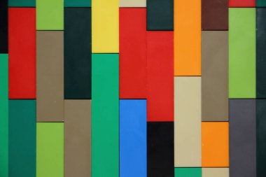 Renkli plastik tuğlalar dikey hatlar duvar yüzeyini kapatın, çocukların inşaat malzemesi arka plan dokusu