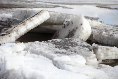Mevsimlik bahar buzu sürükleniyor. Nehir suyundaki hasarlı büyük buz kütlelerine yakından bakıyor.